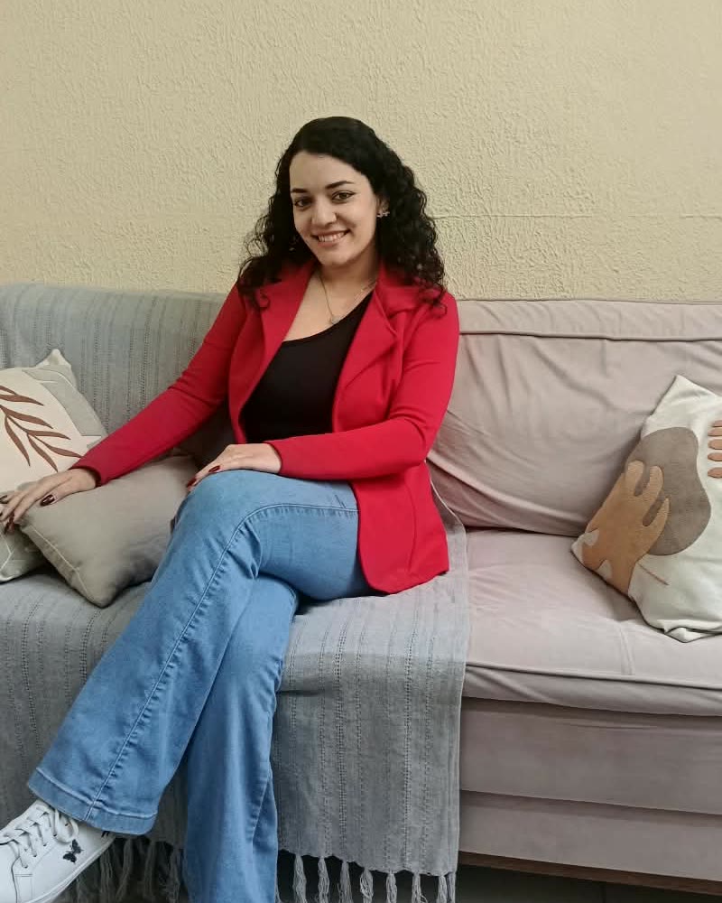 Andreza Furtado Carvalho, psicóloga clínica, sentada no sofá do consultório.